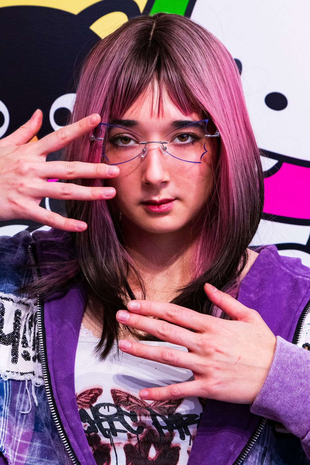 A series of four artistic portraits showing pink hair and hand gestures against colorful backgrounds.