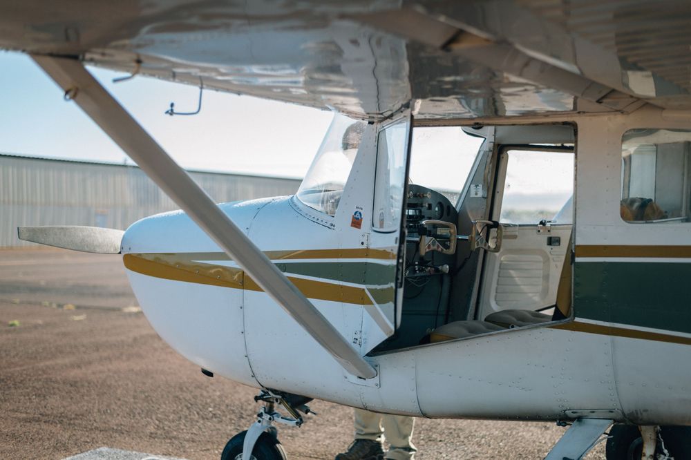 White private aircraft parked on tarmac showing wing and fuselage details.