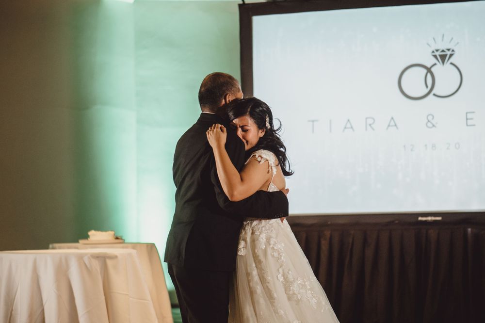 Wedding reception venue setup with projection screen displaying elegant branding.
