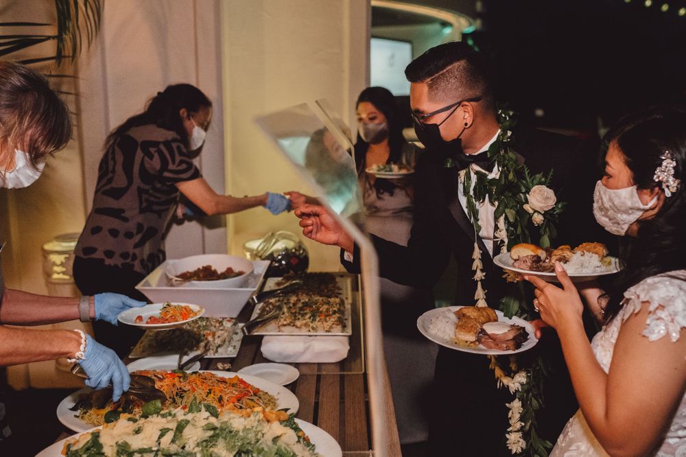 Wedding reception guests enjoying a buffet dinner service at an indoor venue.