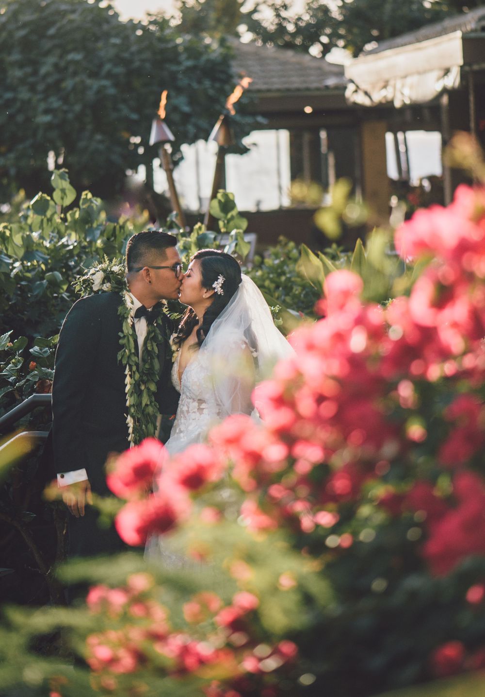 Romantic garden wedding scene with pink bougainvillea flowers in the foreground.