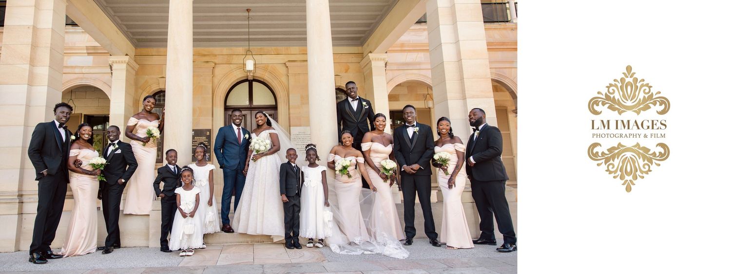 Wedding party poses on grand steps in formal attire with the LM Images branding visible.