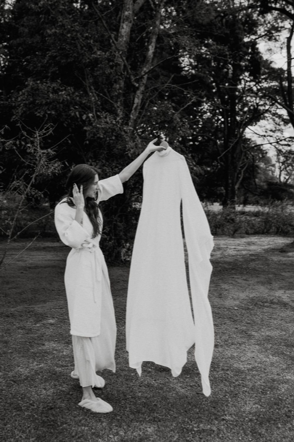 A series of black and white photographs showing white clothing hanging on a clothesline outdoors in a garden setting.