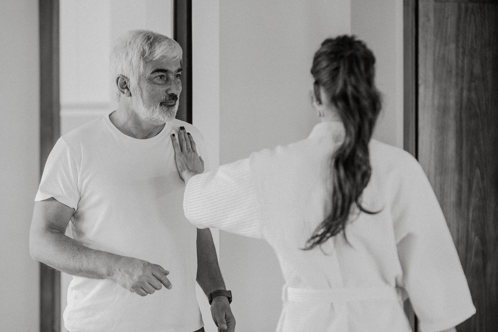People in white robes getting ready in a bright room with natural lighting.