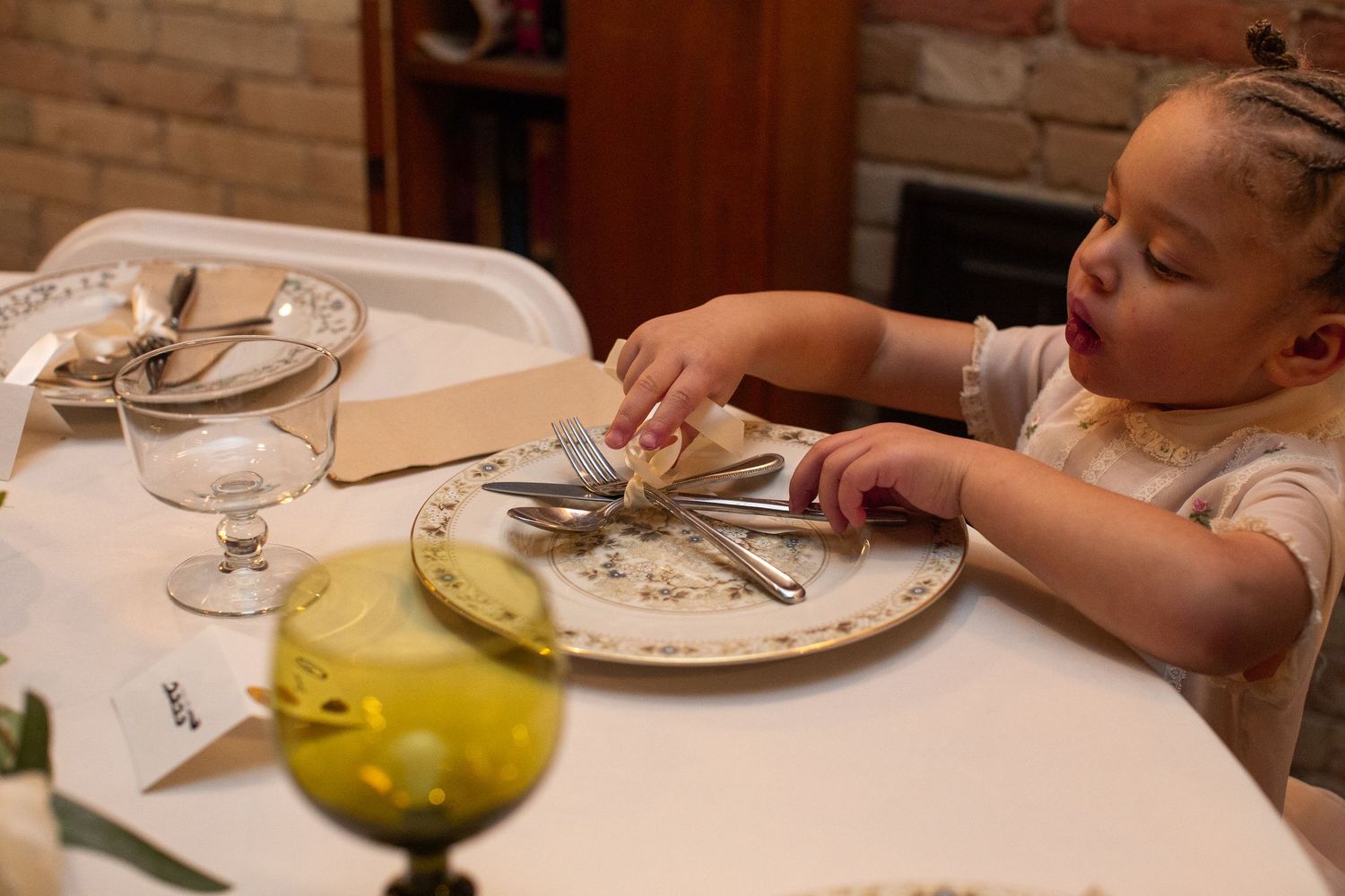 Guests dining at an elegant restaurant table with wine glasses and place settings.
