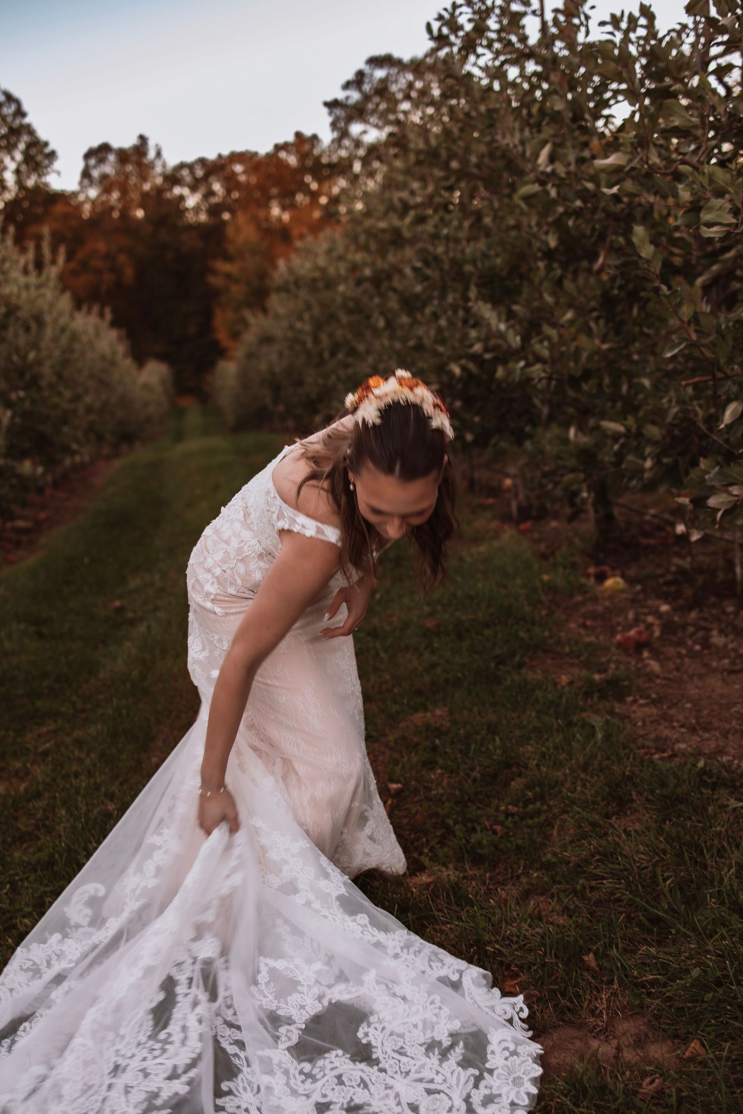 Bride fixing her wedding dress before walking back into the venue captured naturally and unposed.