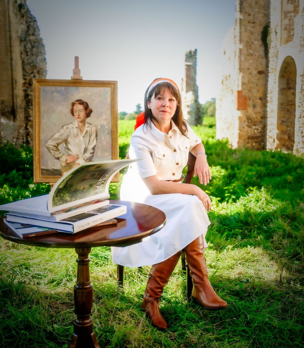Editorial portrait of gallerist Lucy Charles seated with her artwork in Yoxford, Suffolk