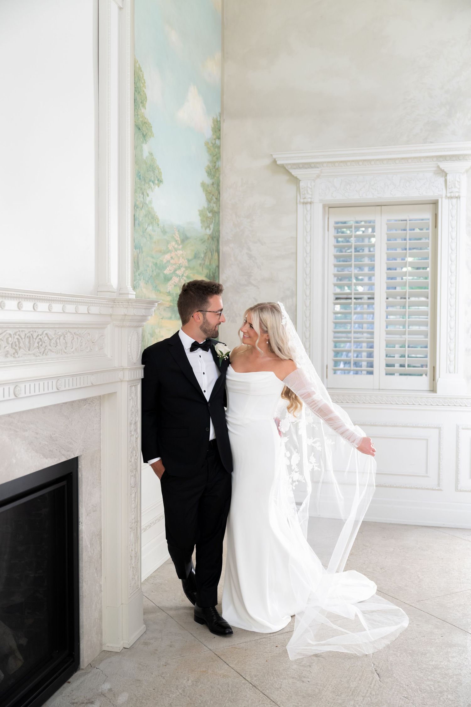 A romantic wedding photo series showing a couple in white dress and black tuxedo posing together in a bright interior space.