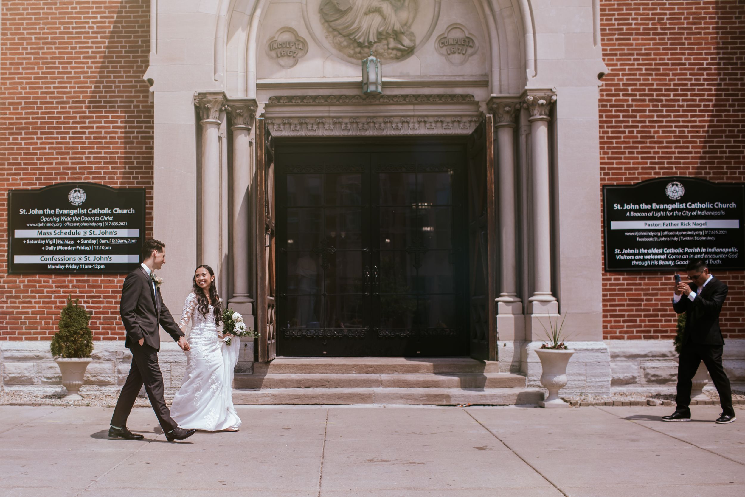 A panoramic view of a brick building entrance with ornate white stone trim and multiple doorways.