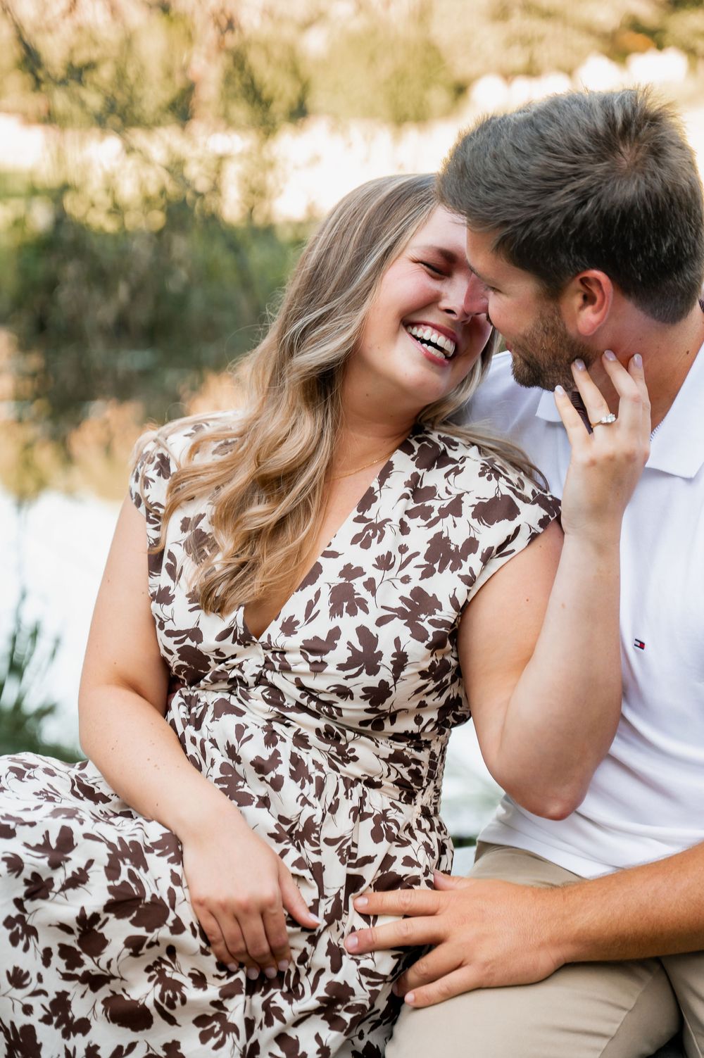 Couple sharing intimate laughs while sitting together in a sunlit outdoor setting.