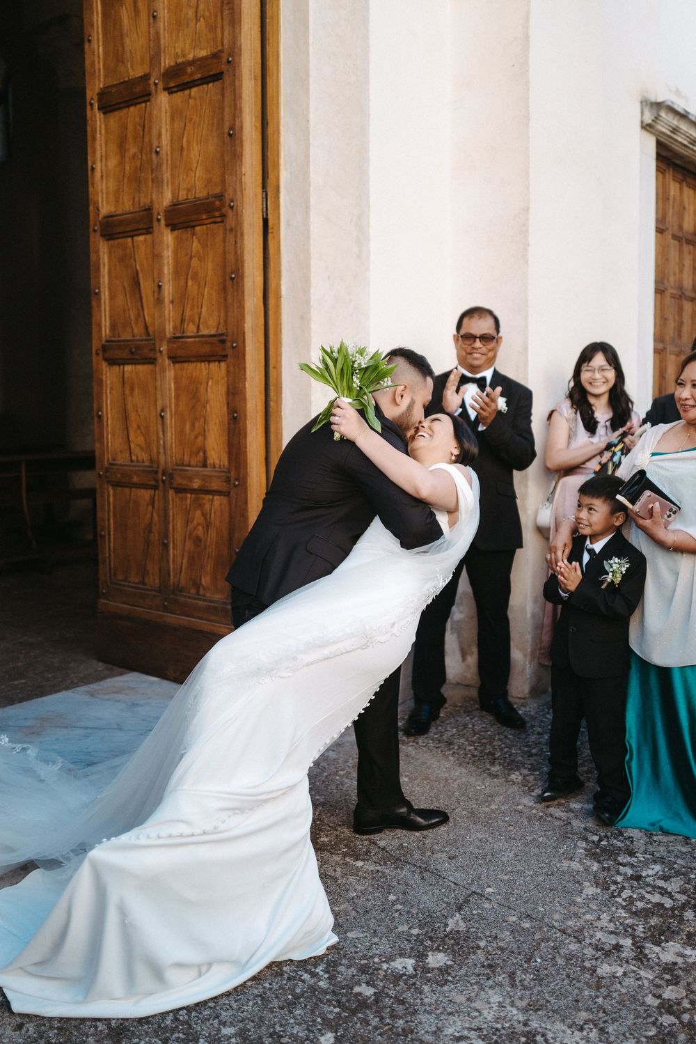 A wedding dress train flows gracefully in a sequence of photos showing movement against rustic wooden doors.