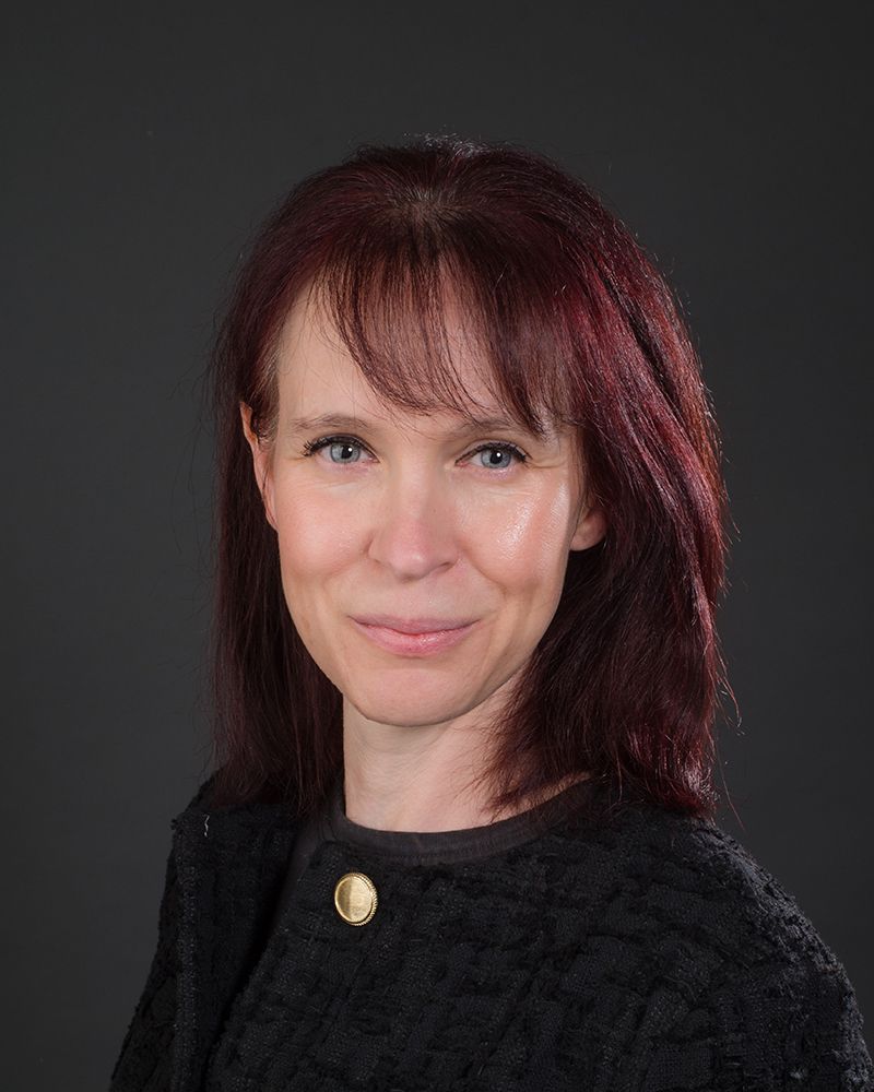 A headshot of a woman with red hair wearing a black jacket, photographed by Abigail's Studio in High Wycombe.