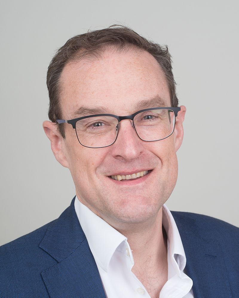 A headshot of a man in a suit and glasses, photographed by Abigail's Studio in High Wycombe.