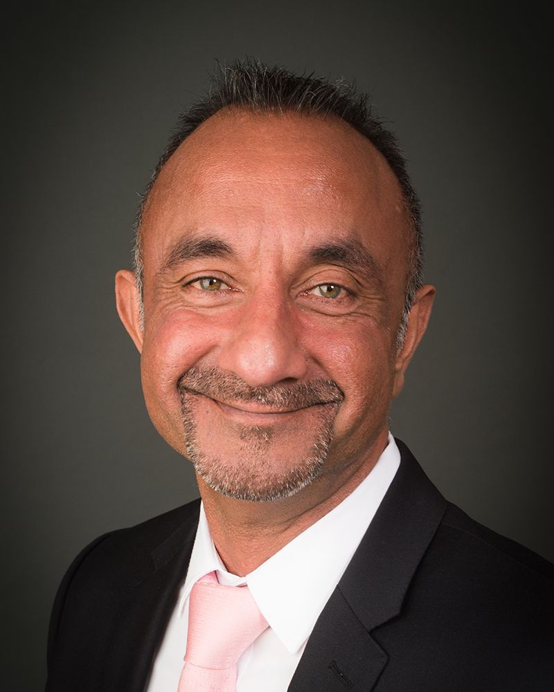 A smiling man in a suit with a pink tie, captured in a headshot by Abigail's Studio in High Wycombe.