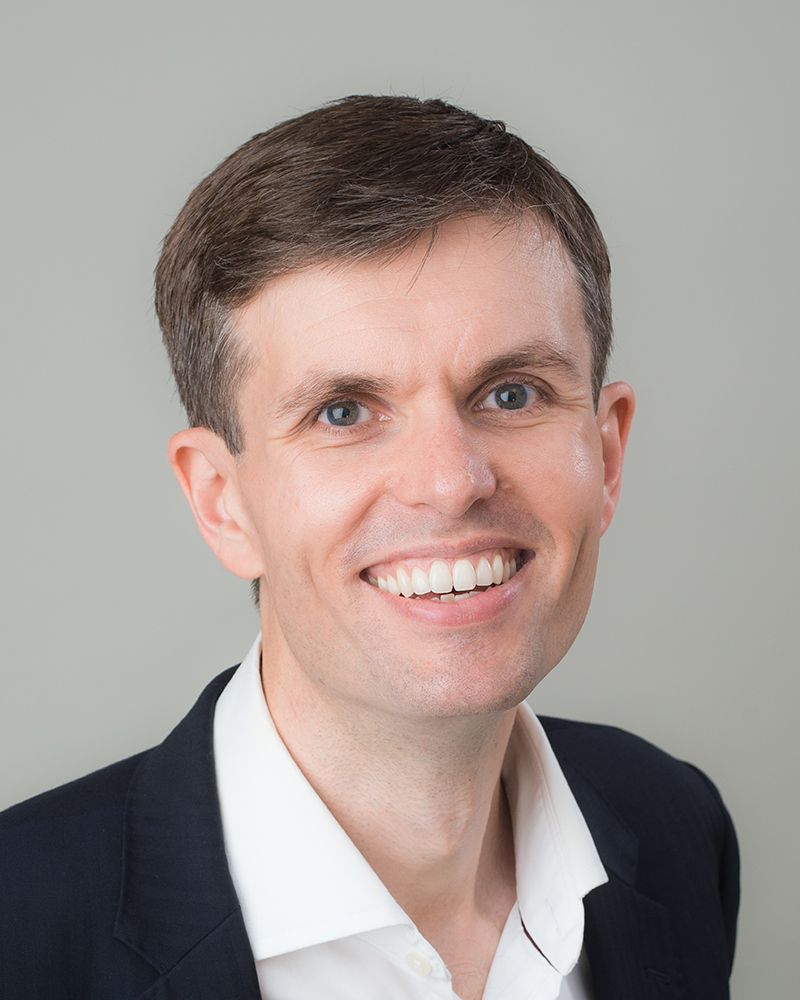 A professional headshot of a smiling man in a suit and tie, taken by Abigail's Studio in High Wycombe.