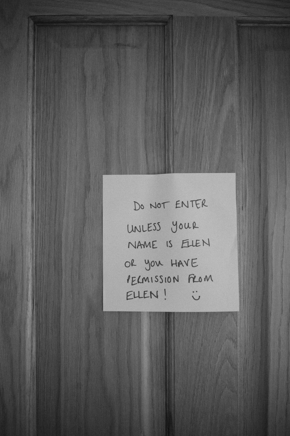 Black and white image of handwritten 'Do Not Enter' signs on wooden panels.