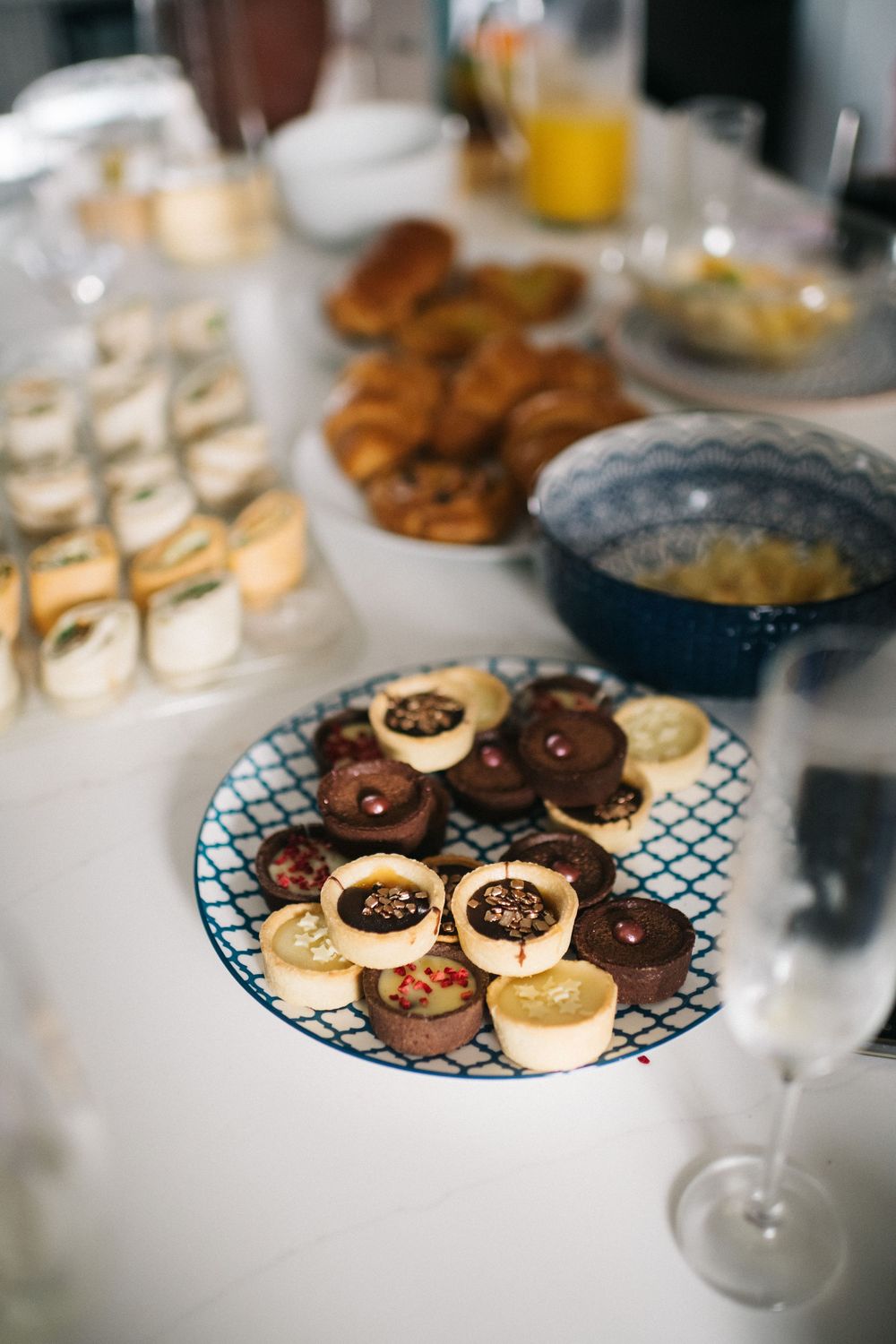 An assortment of chocolate and vanilla cookies displayed on a decorative blue and white plate at a wedding dessert table.