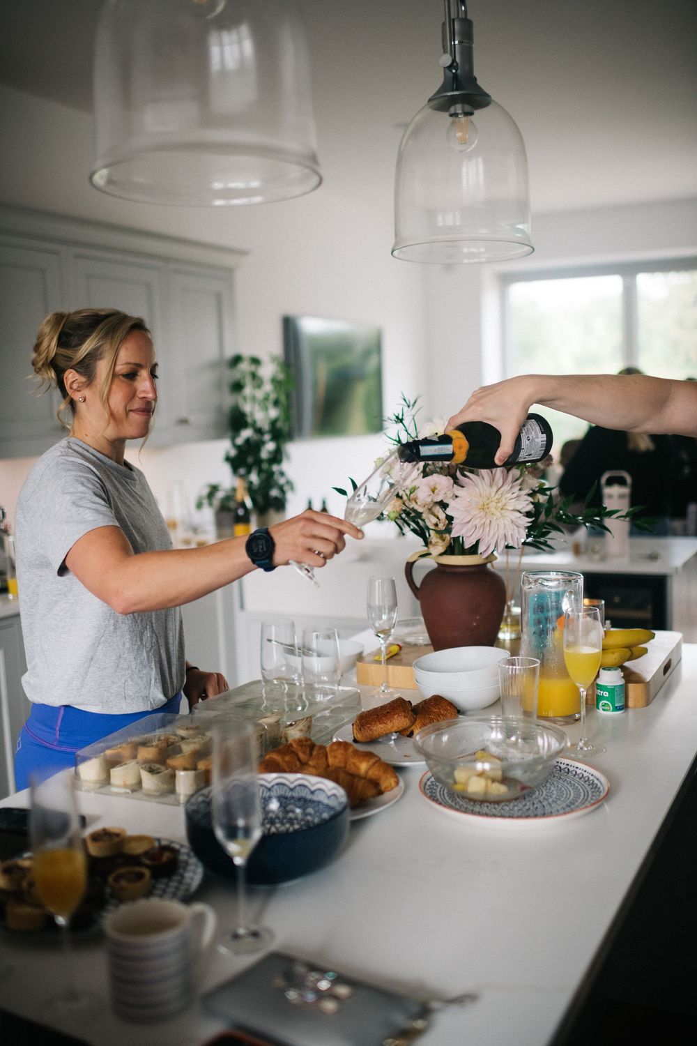 Wedding morning preparations with breakfast and drinks laid out on a bright white kitchen counter.