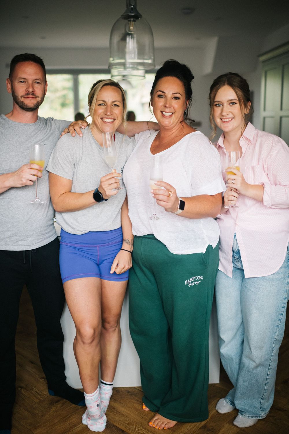 A group in casual attire posing together and laughing while wearing white shirts and blue shorts.
