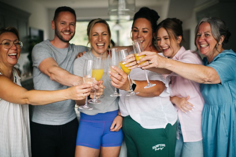 Wedding party celebrates with drinks and toasts in casual attire.