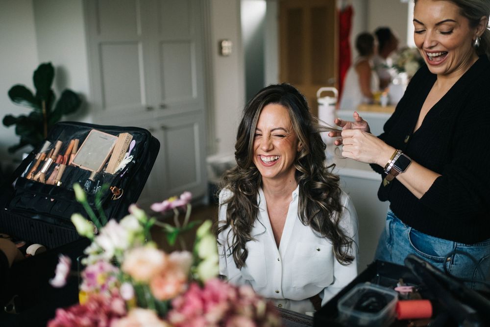 Getting ready moments captured in bright indoor setting with natural light.