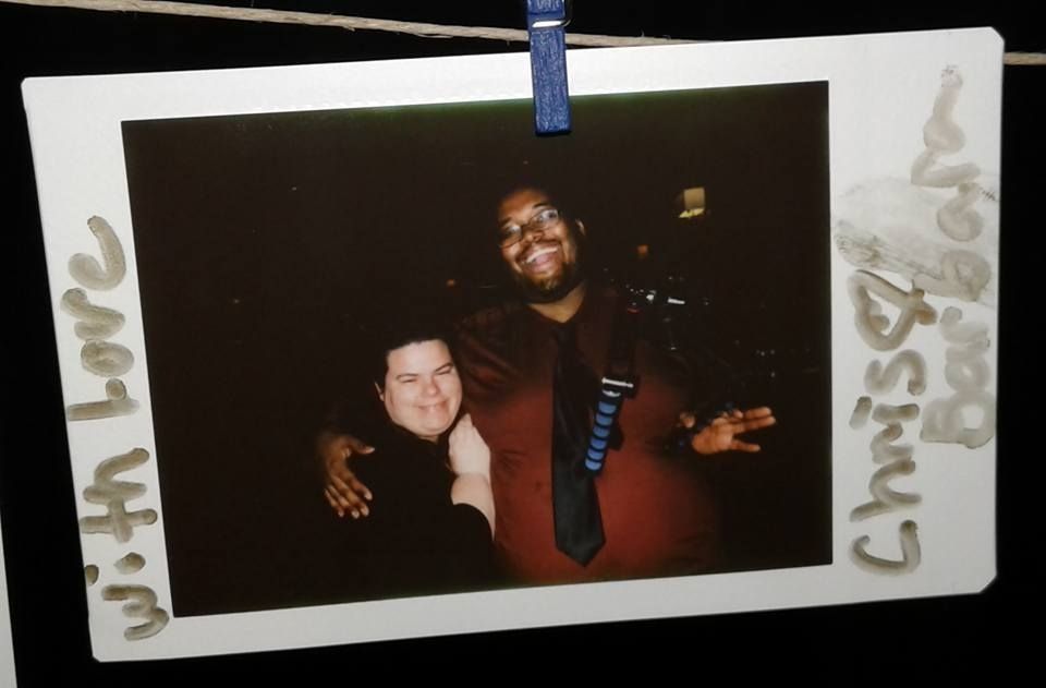 A series of dark polaroid photographs hanging on a clothesline with blue clips against a white background.