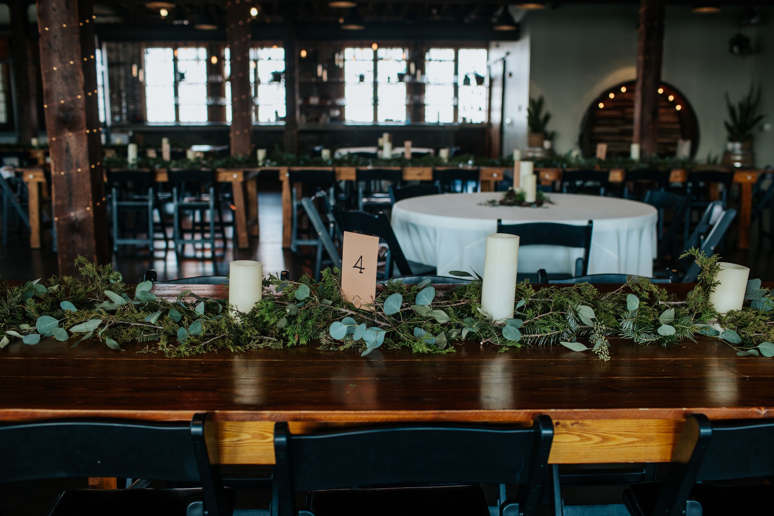 Modern restaurant interior with wooden tables, pendant lighting, and exposed brick walls creates an industrial-chic atmosphere.