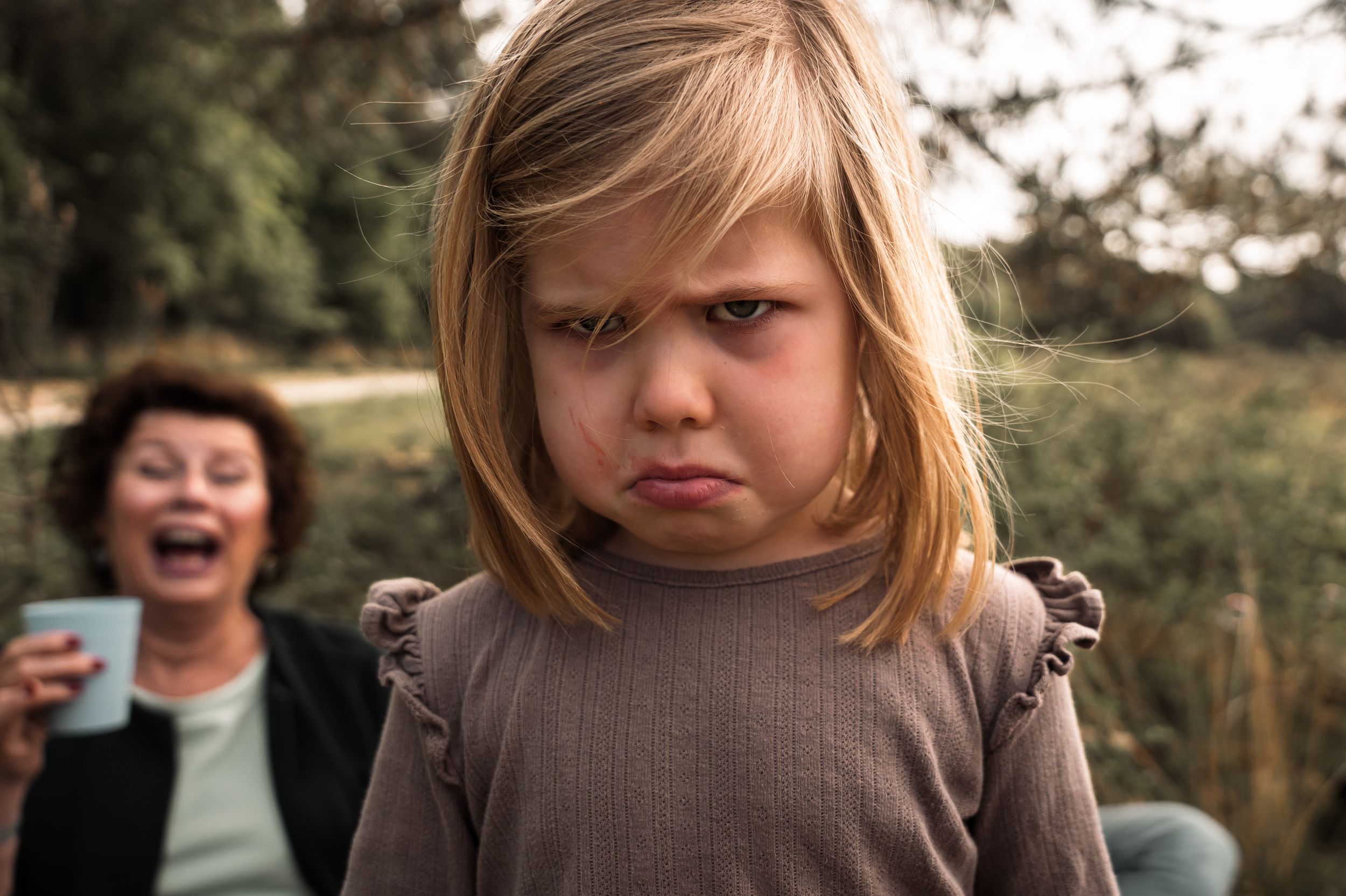 A series of five candid photos showing a range of emotions and expressions in natural outdoor lighting.