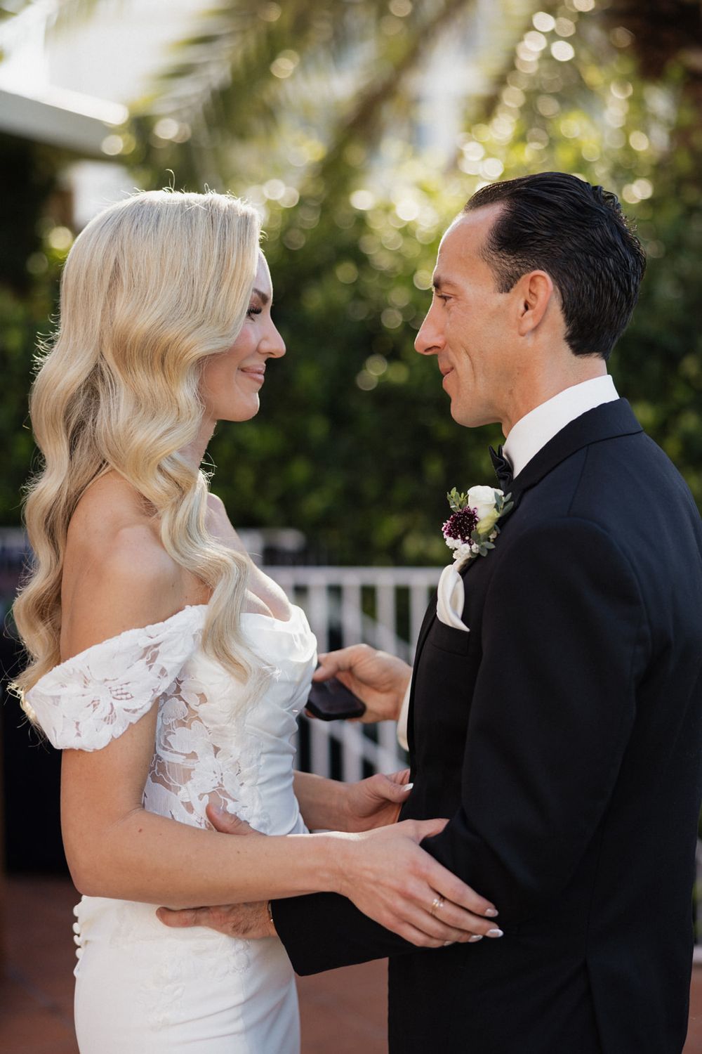 A couple shares a romantic moment in their wedding attire during an outdoor photo session.