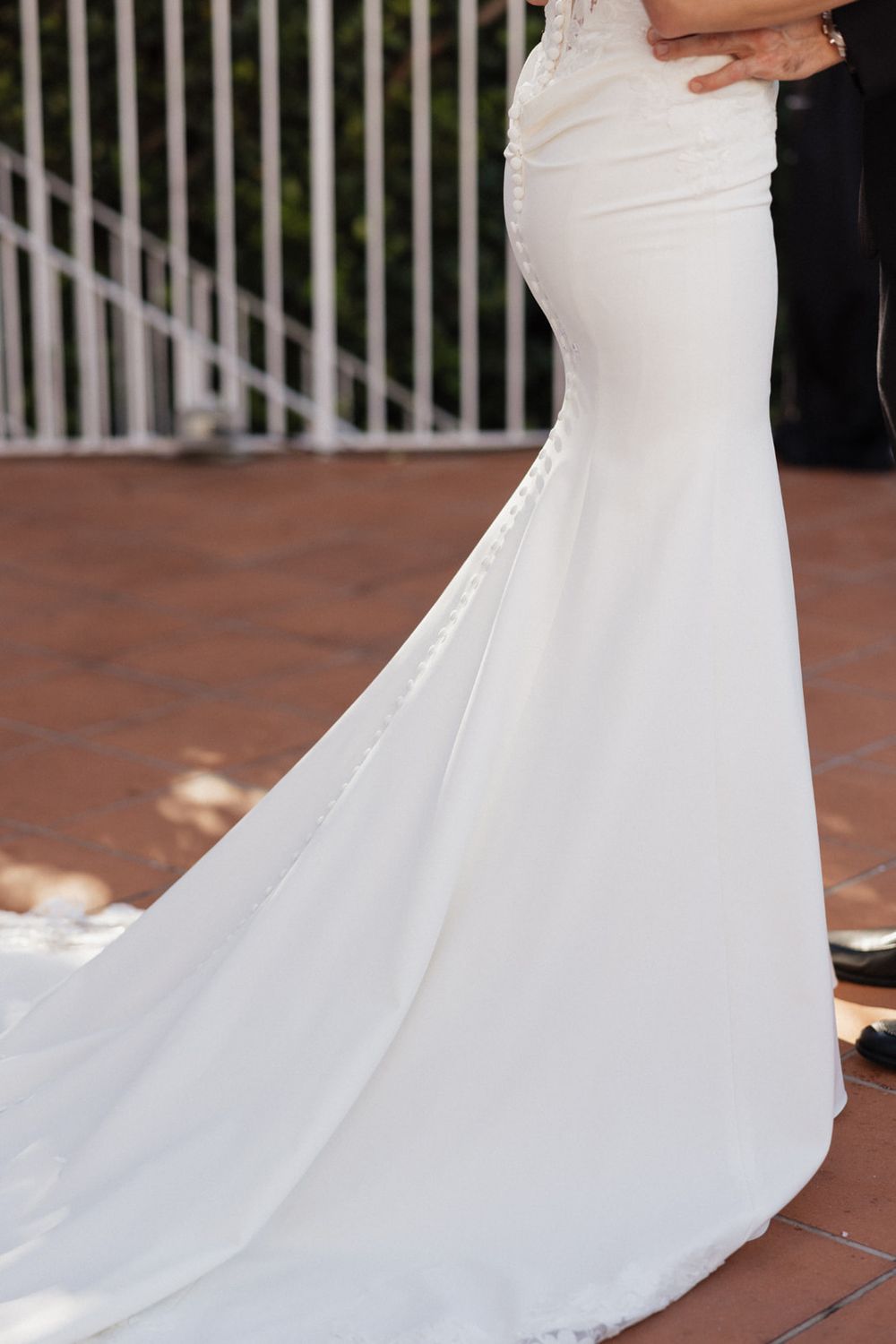 Close-up shots of a flowing white wedding dress train on terracotta tiles.