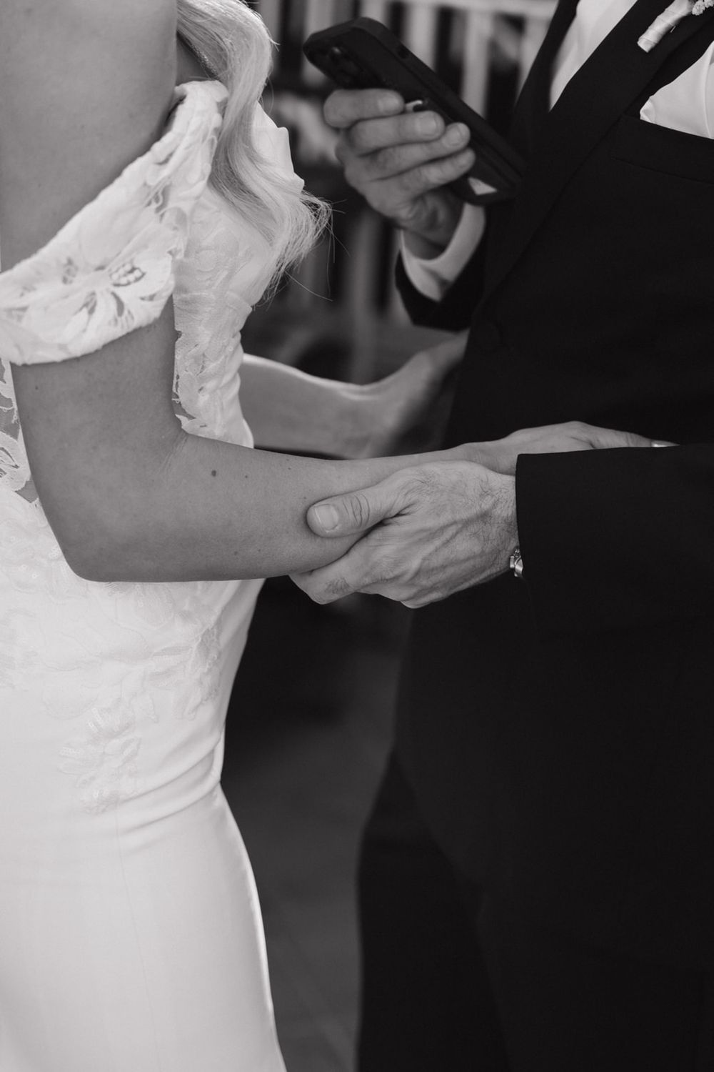 Close-up black and white photos of a couple dancing at a wedding reception, focusing on their formal attire and embrace.