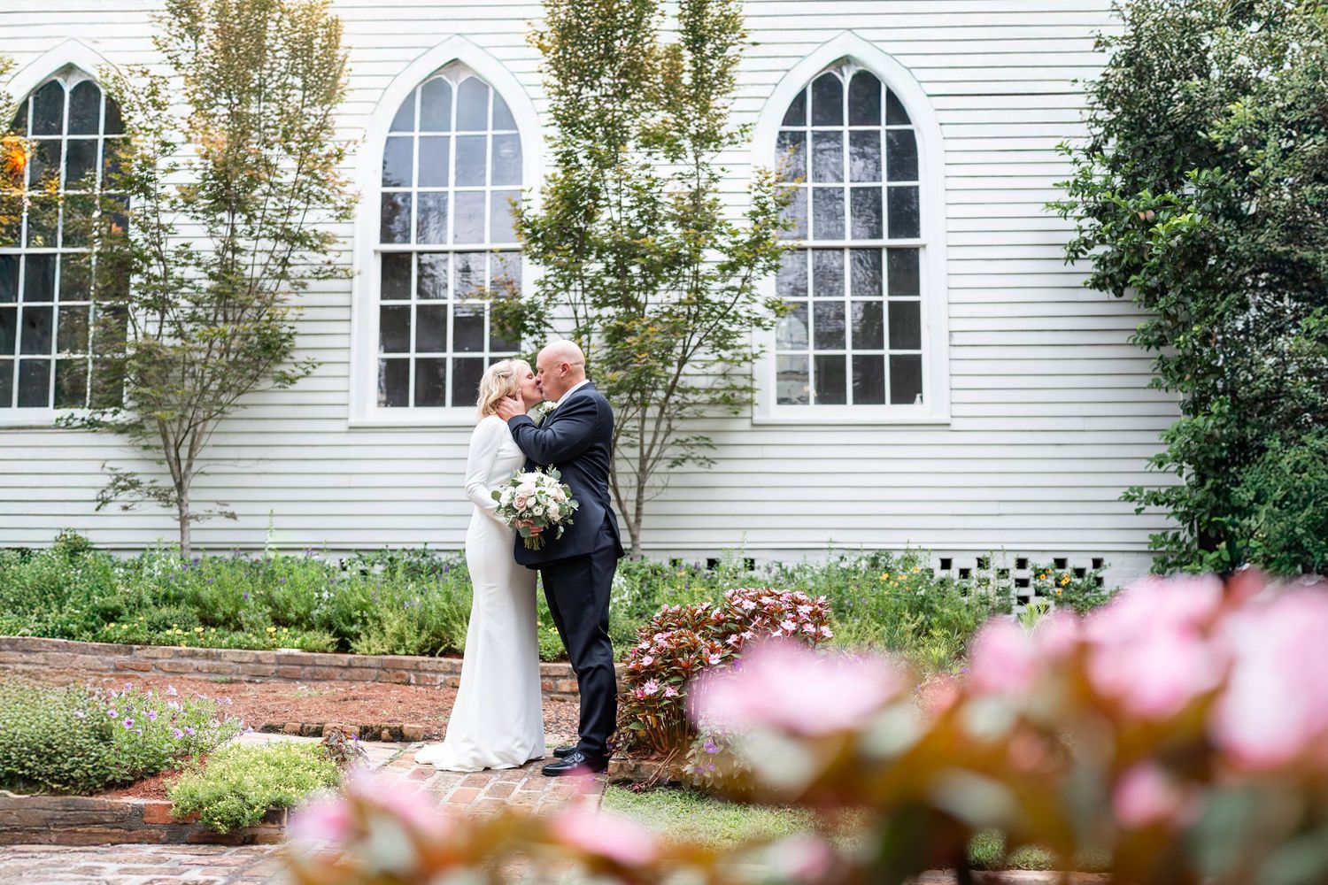 older bride and groom kiss by christ's episcopal church in covington, LA
