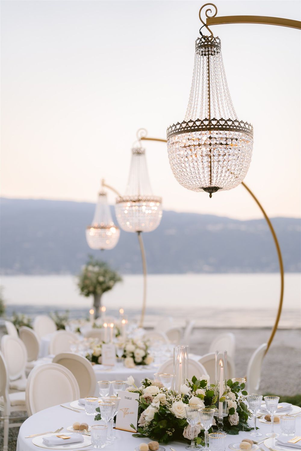 Crystal drop chandeliers and golden arches decorating the reception area in the garden of Villa Bettoni