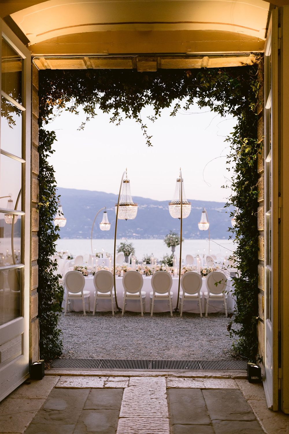 Crystal drop chandeliers and golden arches decorating the reception area in the garden of Villa Bettoni