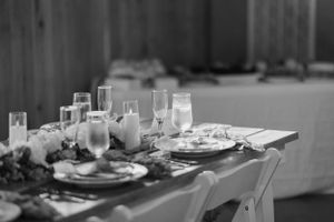 Elegant wedding table setting with glassware and floral centerpiece in black and white.