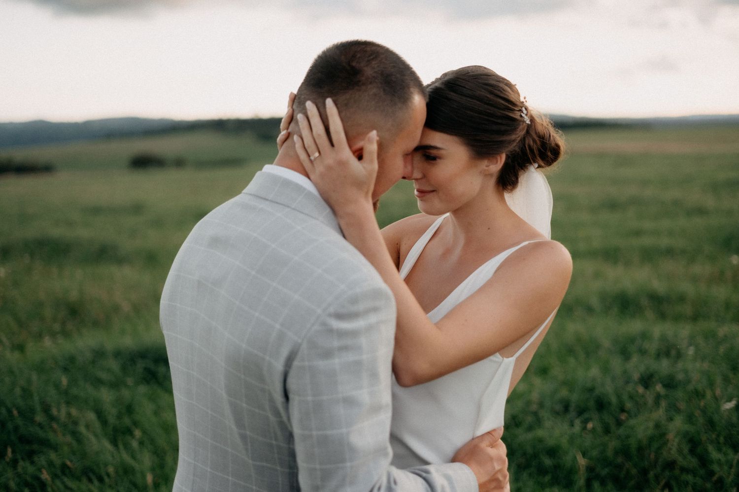 A black and white panoramic sequence shows a couple dancing together in an open field at sunset.