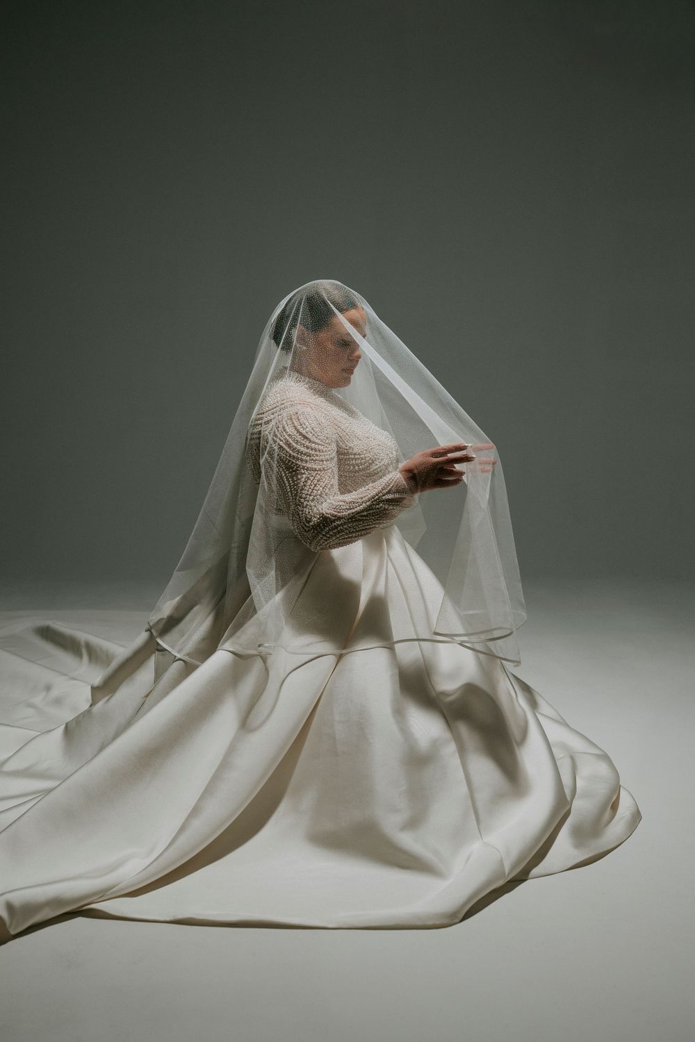 Artistic series of minimalist photos showing flowing white fabric against a dark background in graceful sculptural forms.