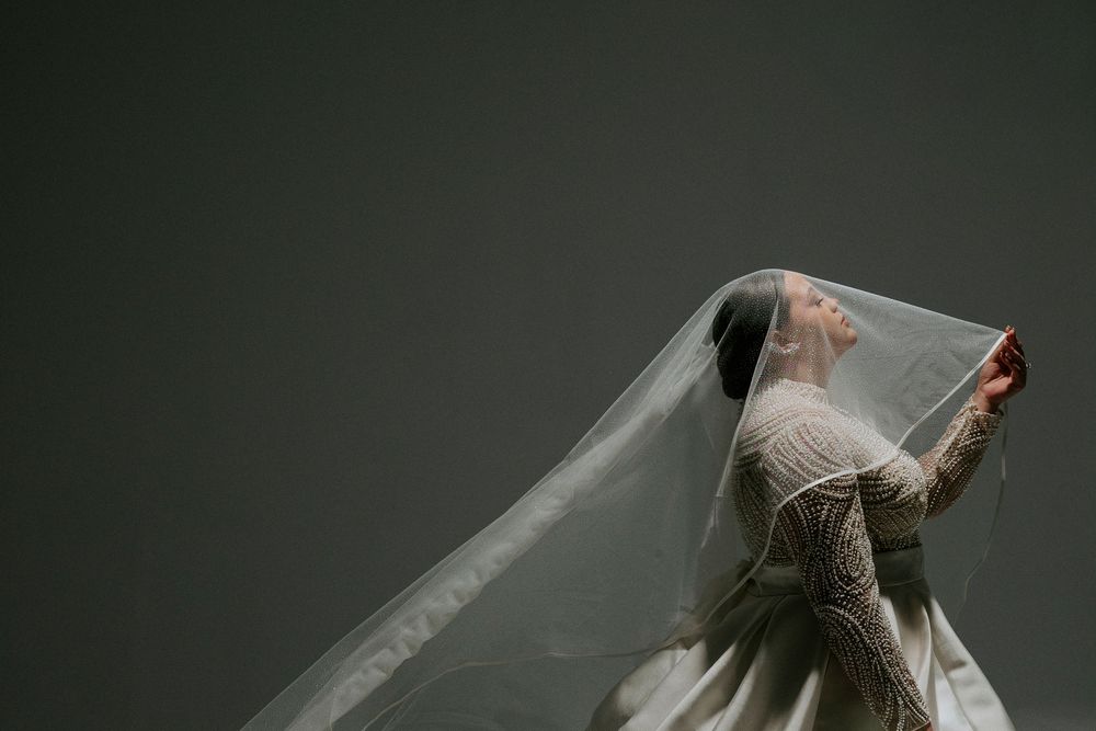 Artistic sequence of someone in white clothing performing expressive dance movements against a dark background.