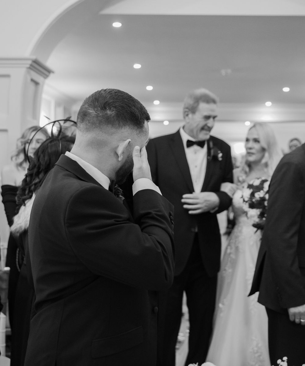 Wedding reception guests in formal attire mingling and dancing in an elegant ballroom setting.