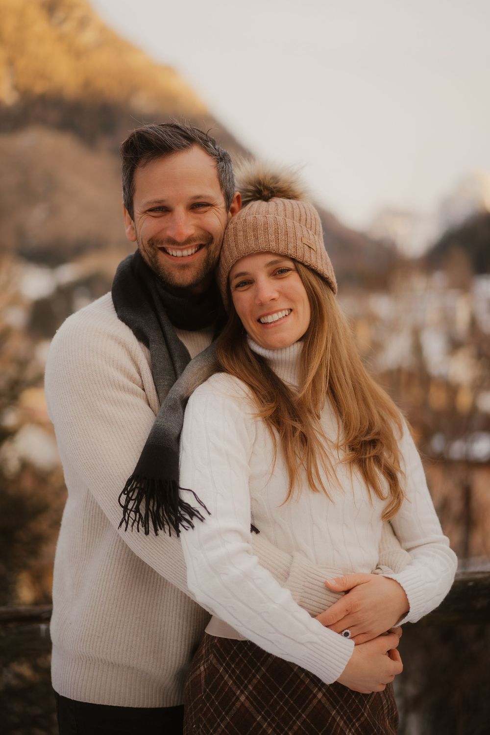Sweet embrace of an international couple keeping warm during a windy mountain photoshoot.