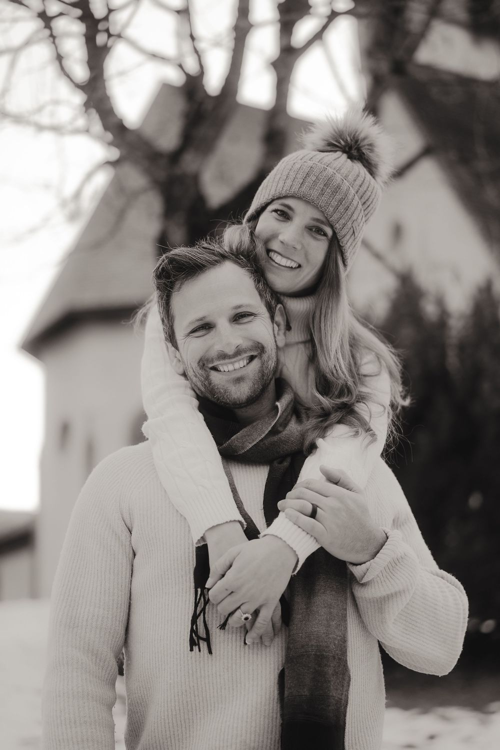 American couple exploring a scenic alpine landscape during their destination engagement shoot.