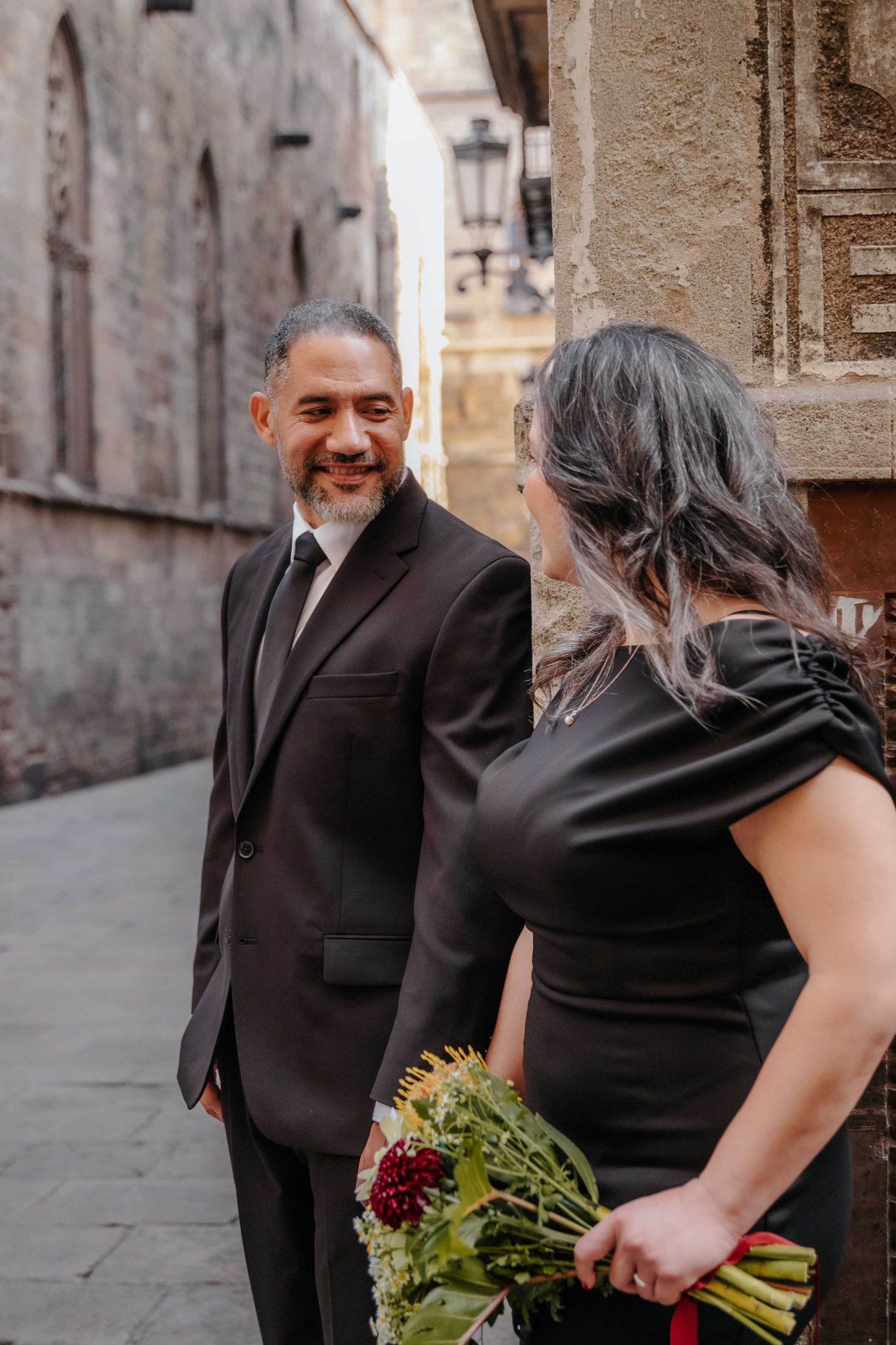 Childhood sweethearts looking at each other with deep love in Gothic Quarter.