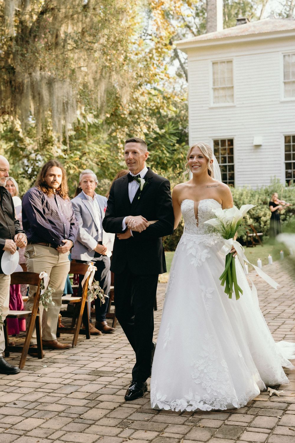 The bride walking down the aisle with her father during the ceremony at The Elms of Coosada in Coosada, Alabama