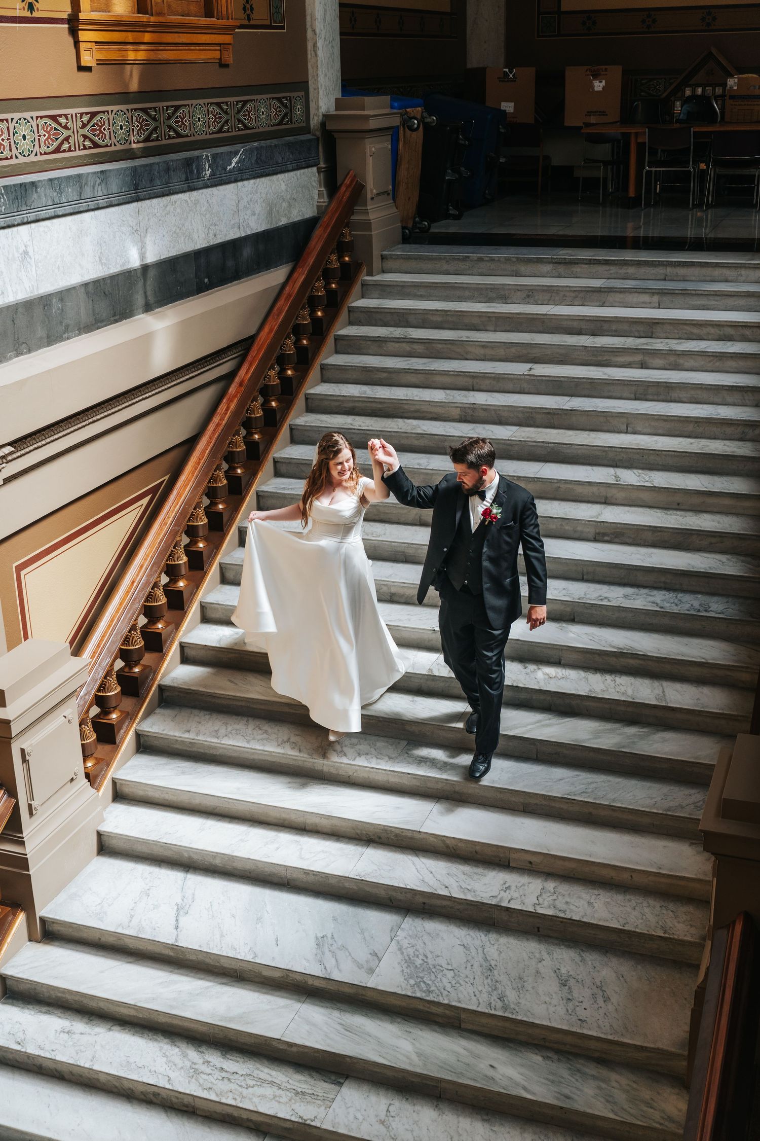 Elegant wedding photo series on grand marble steps inside a historic building.