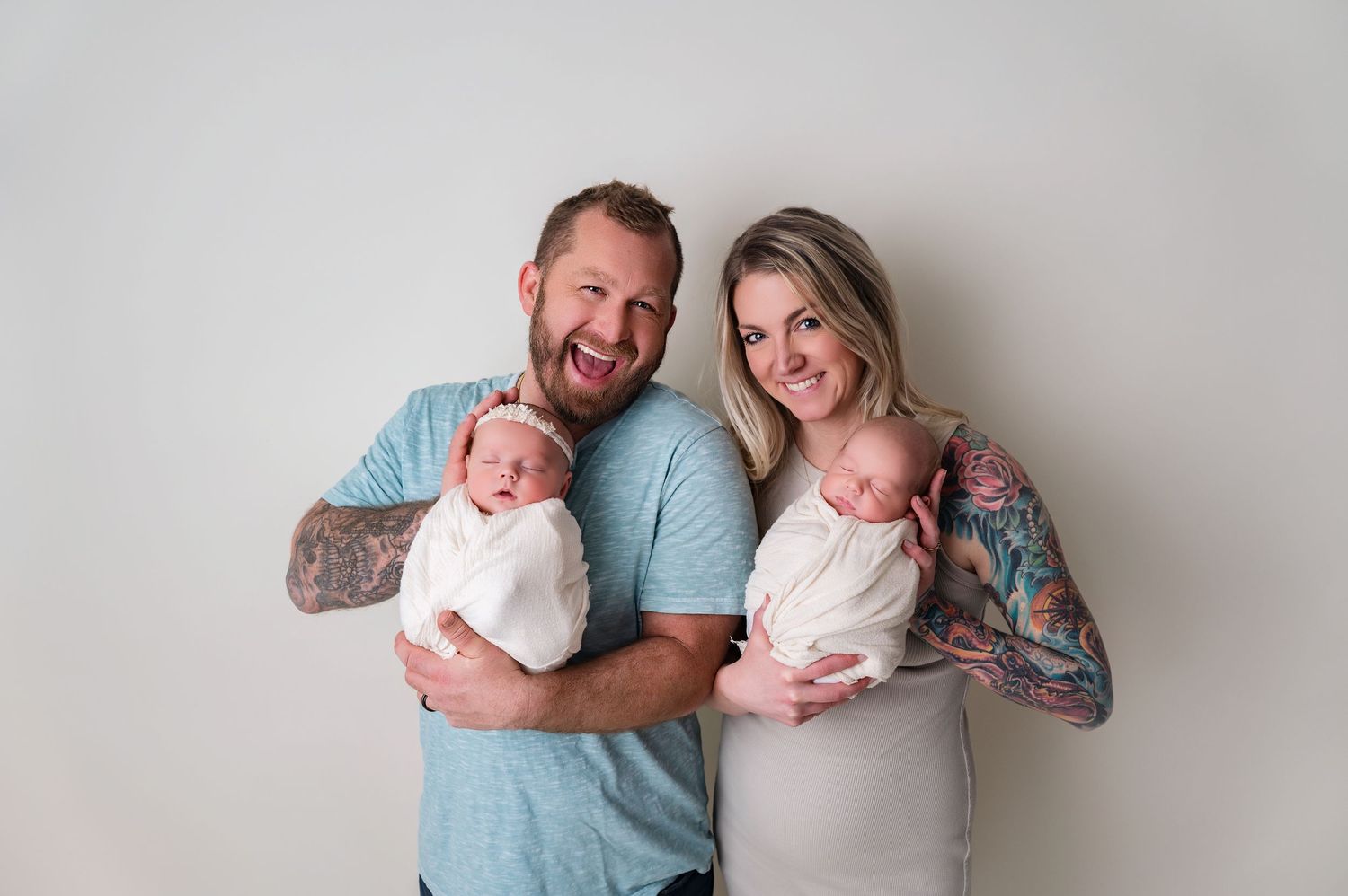 Mother and father smiling and cuddling newborn  twins
