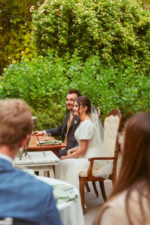 A joyful wedding ceremony moment captured at an outdoor venue with lush greenery in the background.