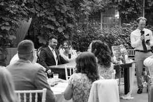 Black and white photo of wedding guests seated at tables during an outdoor reception.