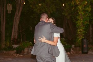 Couple embracing during their wedding dance on an outdoor patio.
