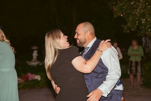 A couple sharing an intimate dance moment at an outdoor evening celebration.