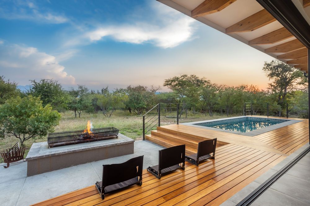 Luxury villa exterior at sunset with pool and patio area